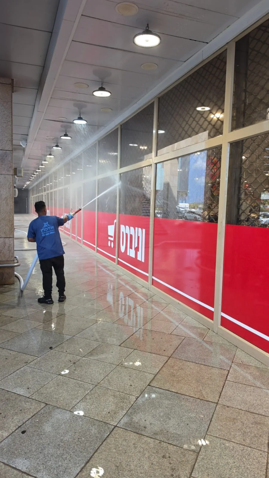 עובד גולד קלין שוטף חלונות ראווה של חנות